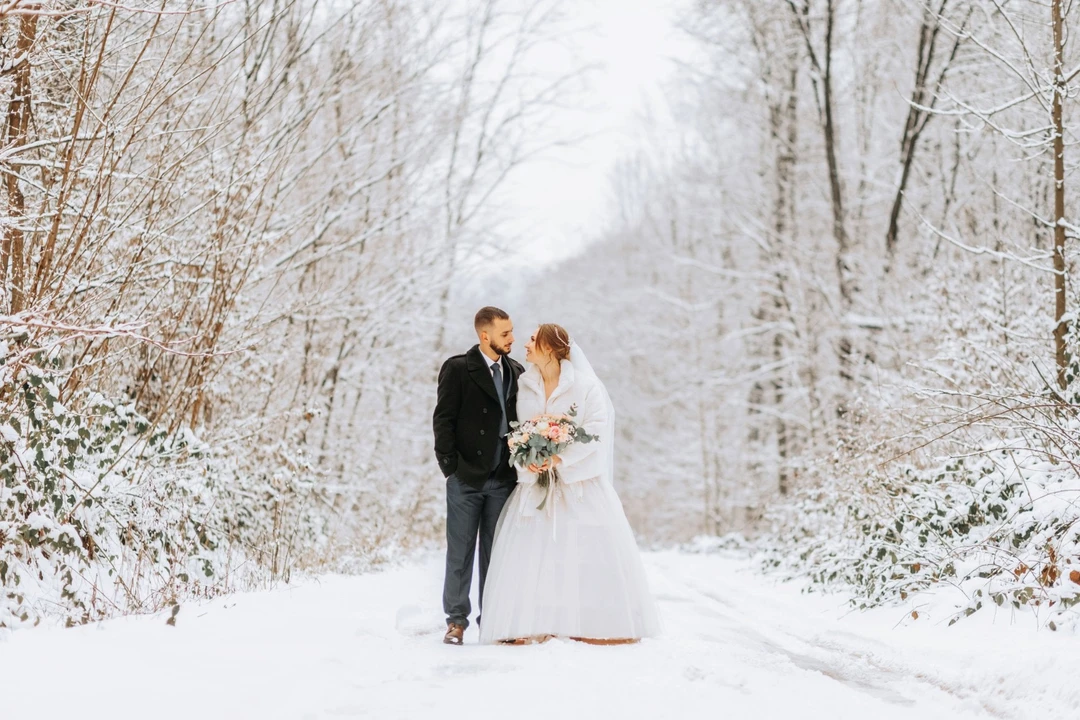 beautiful-wedding-couple-walking-winter-snowy-forest-woman-white-dress-mink-fur-coat-bearded-man-black-coat.jpg